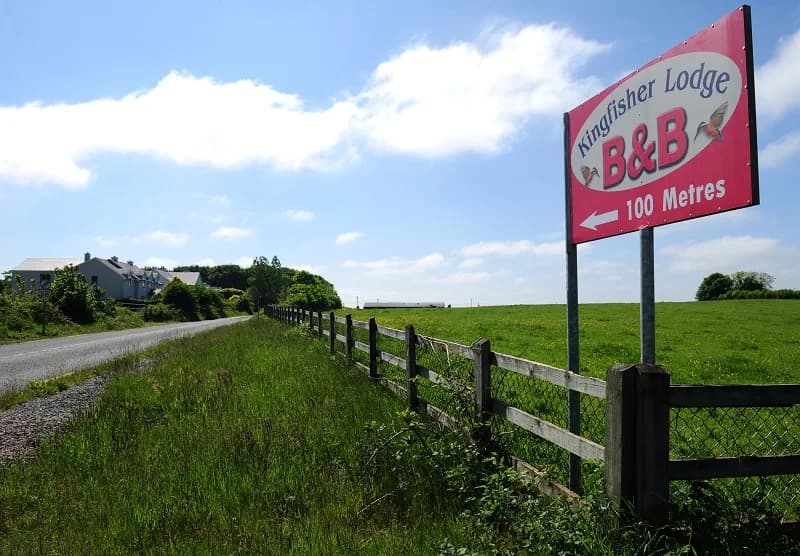 The Kingfisher Lodge sign on the roadside, pointing to the house 100 metres ahead
